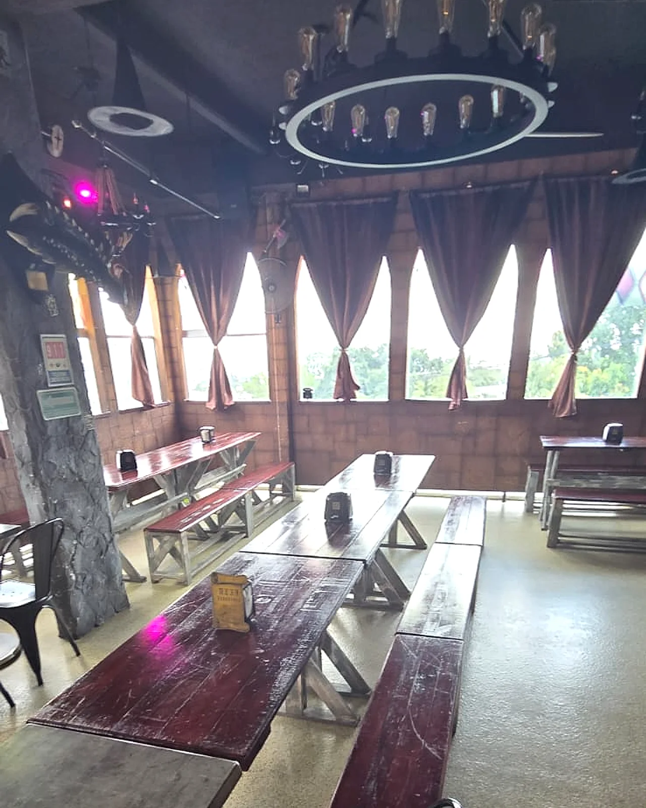Salón de Arcanum Domus con mesas de madera y ventanales