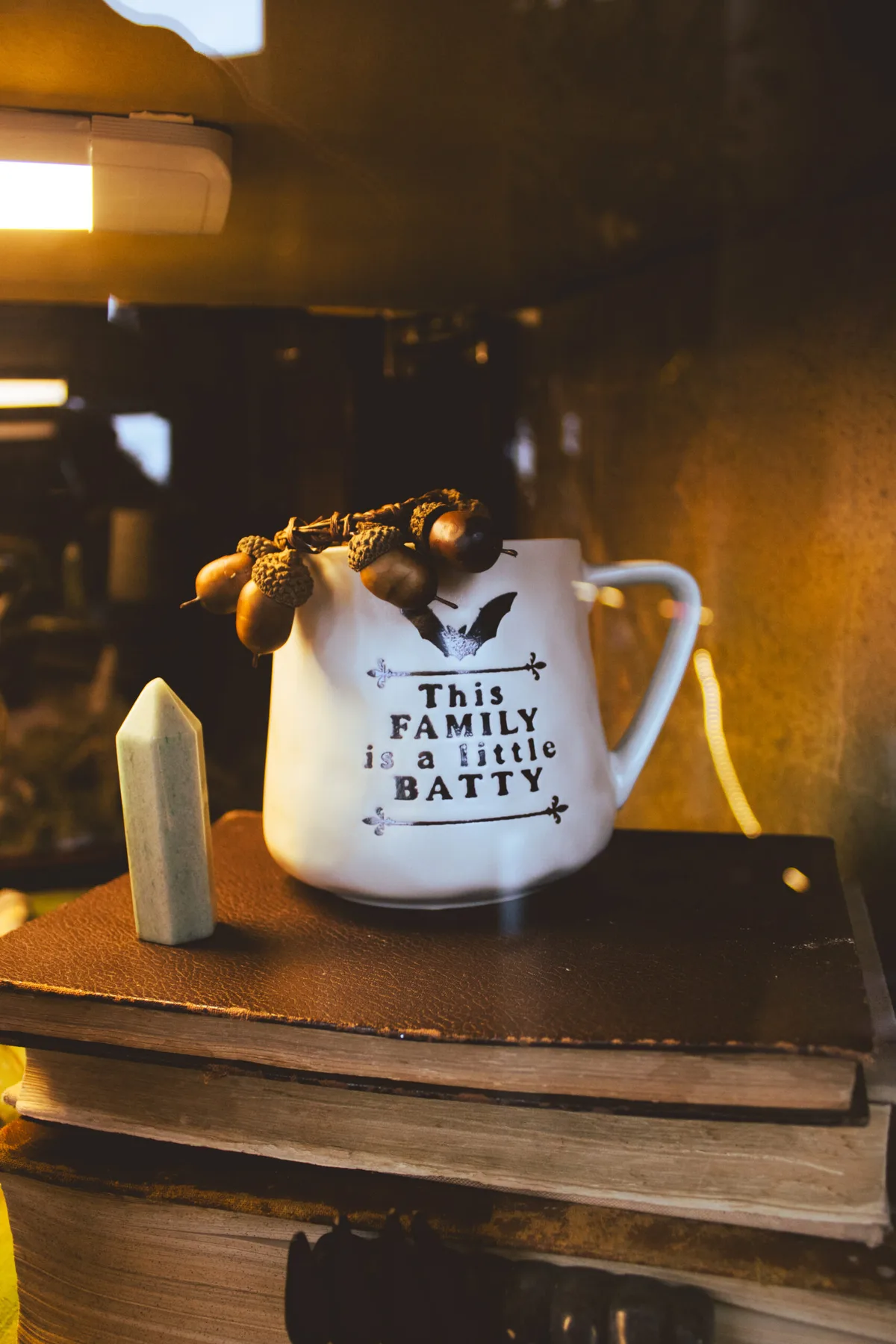 Taza blanca con murciélago y bellotas en la barra de Arcanum Domus