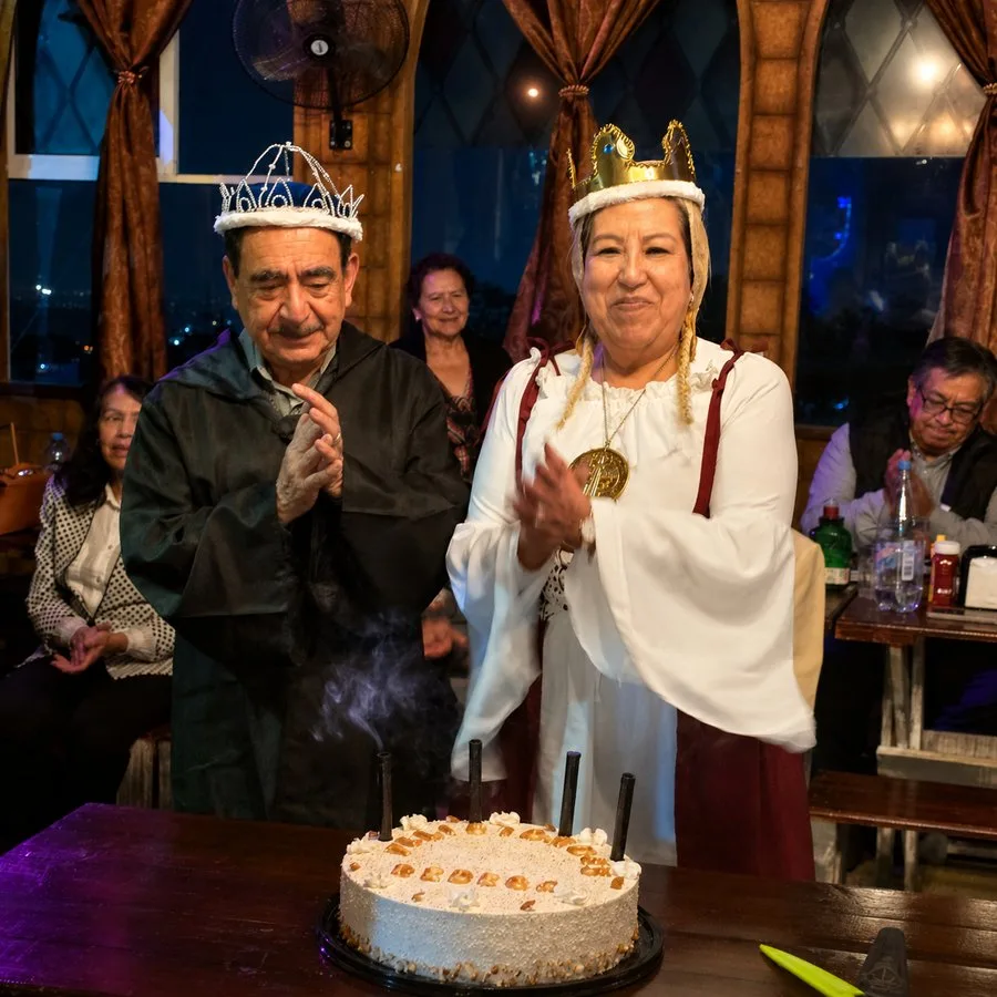 Pareja con coronas celebrando con pastel en Arcanum Domus