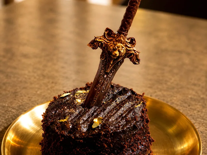 Pastel de chocolate con una espada clavada en Arcanum Domus